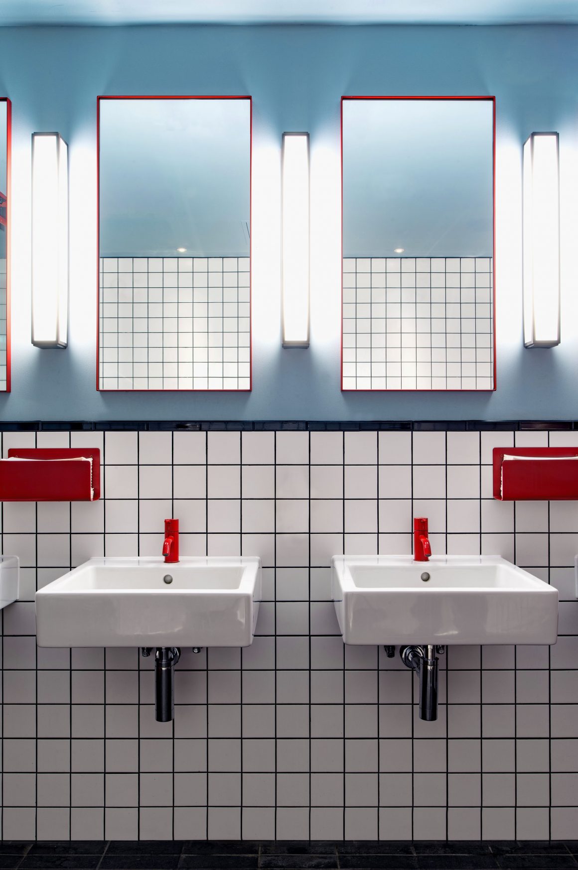 White grid bathroom with red taps